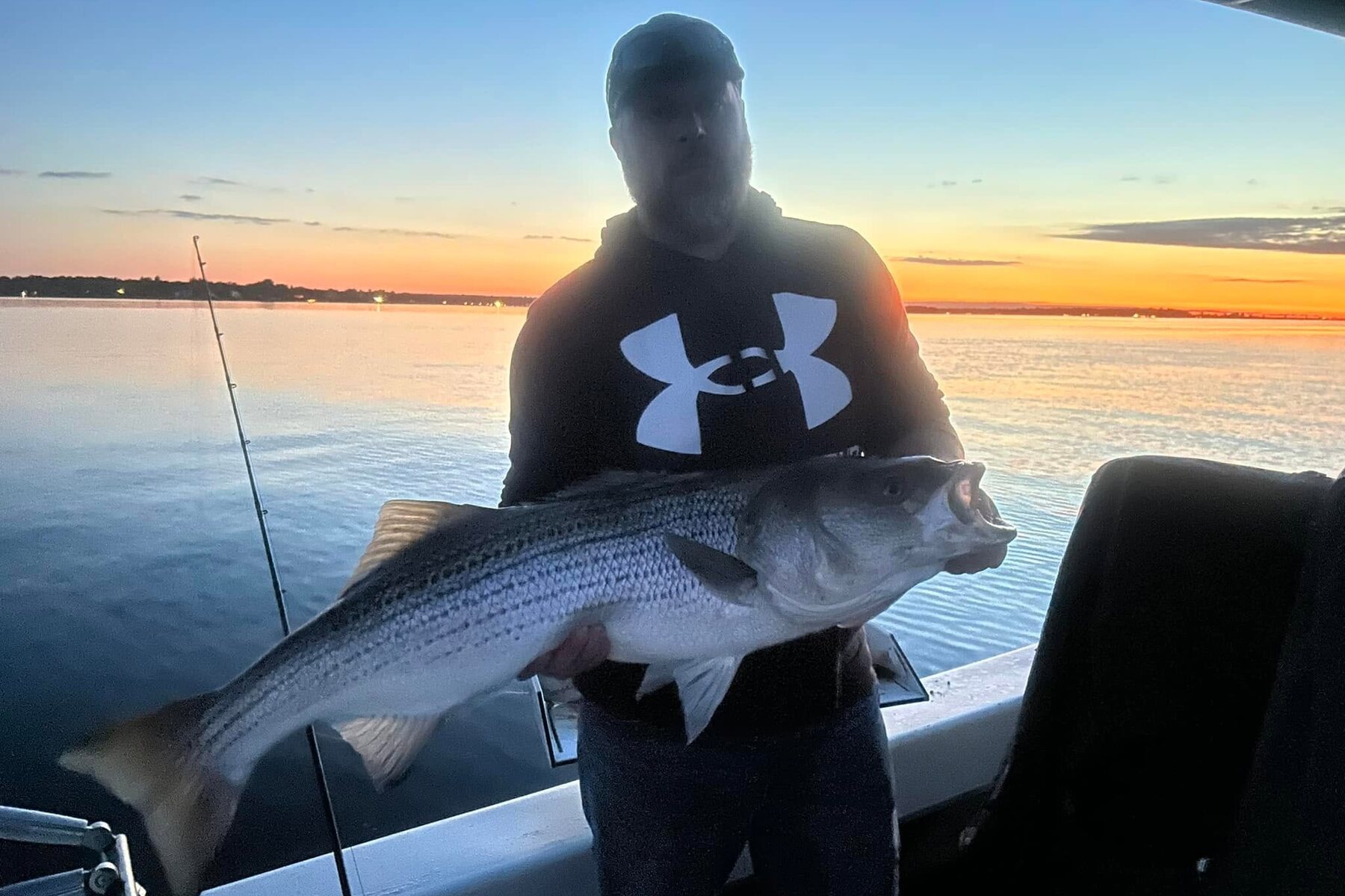 A striped bass on deck at sunset