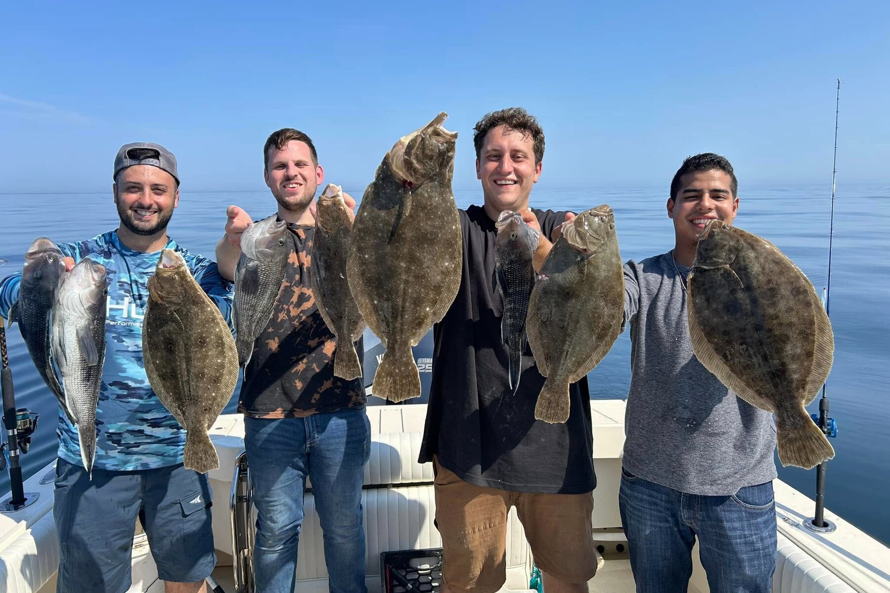 A group of anglers with a catch of fluke on open water